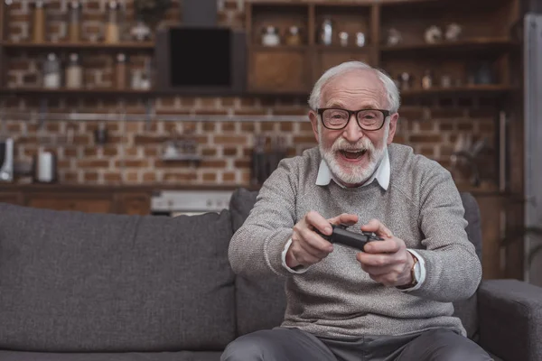 Homme âgé jouant au jeu vidéo — Photo de stock