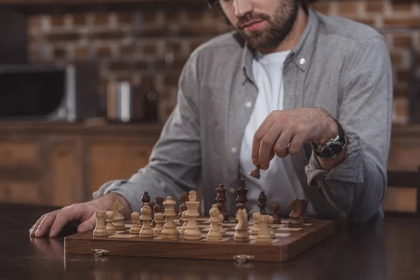 Imagen recortada del hombre jugando al ajedrez en casa - foto de stock