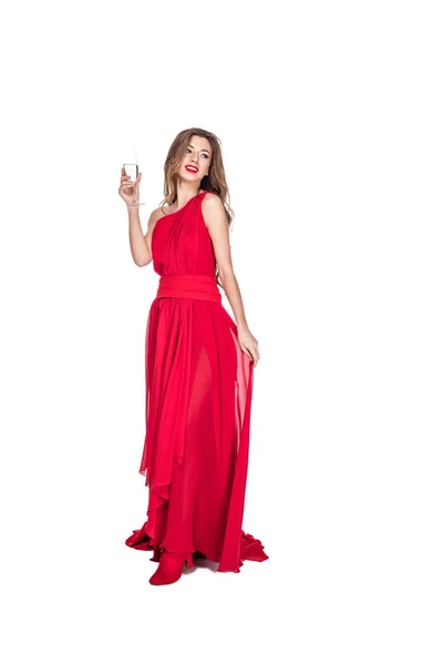 Attractive girl posing in red chiffon dress with champagne glass, isolated on white — Stock Photo