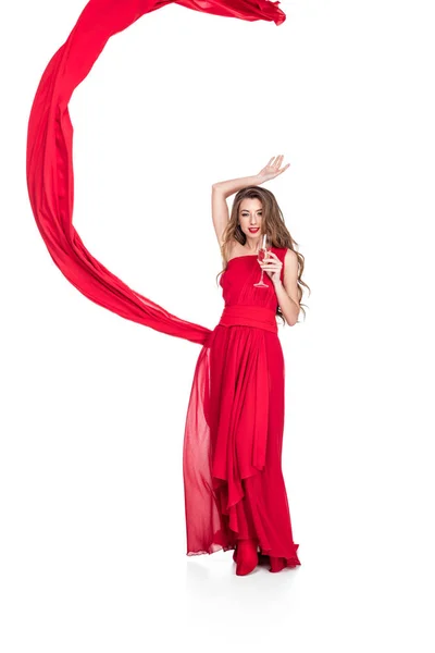 Menina glamourosa em vermelho com véu chiffon segurando copo de champanhe, isolado em branco — Fotografia de Stock