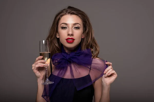 Chica atractiva posando con copa de champán, aislado en gris - foto de stock
