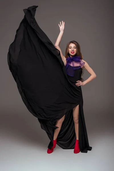 Belle fille posant en robe noire et écharpe violette pour le tournage de mode, isolé sur gris — Photo de stock