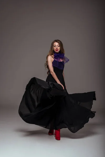 Hermosa chica posando en vestido negro para la sesión de moda, en gris - foto de stock