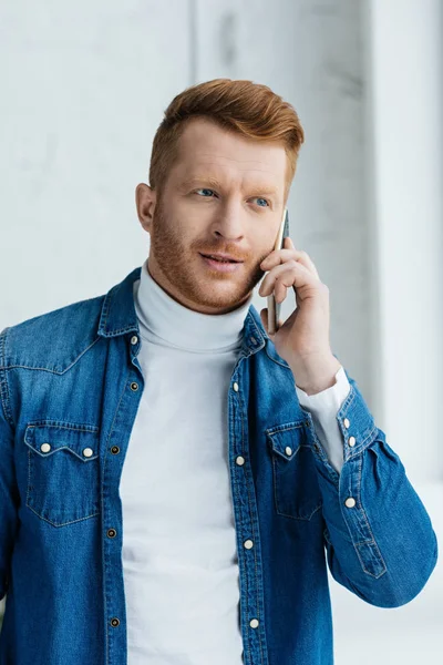 Bello uomo barbuto che parla al telefono dalla finestra — Foto stock