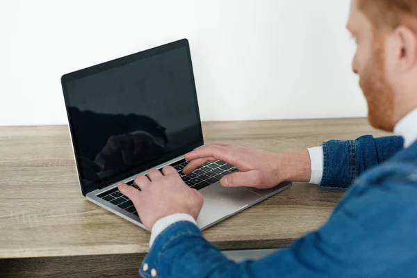 Pelirroja hombre escribiendo en el teclado del ordenador portátil - foto de stock