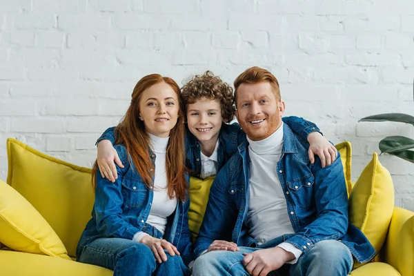 Обнимающий сын и родители сидят на диване — стоковое фото