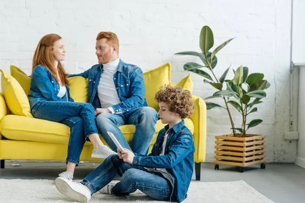 Son using tablet while parents sitting on sofa — Stock Photo