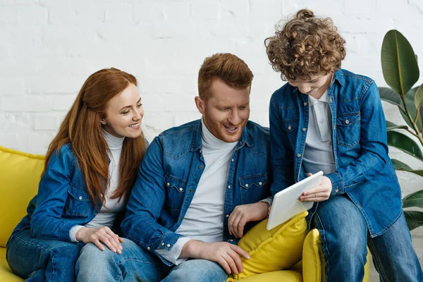 Eltern und Sohn blicken auf Bildschirm des digitalen Tablets — Stockfoto