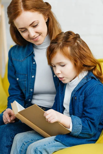 Mère et fille lisent ensemble un livre — Photo de stock