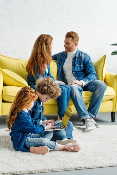 Les parents parlent pendant que les enfants utilisent un ordinateur portable — Photo de stock