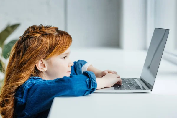 Criança ruiva bonito usando laptop por janela — Fotografia de Stock