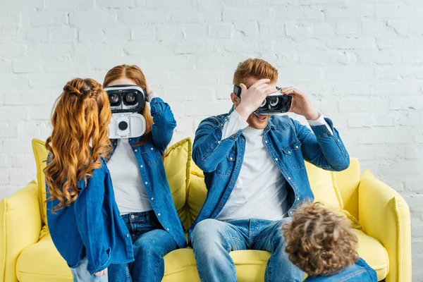 Pais vestindo óculos 3d enquanto sentados no sofá com seus filhos no quarto — Fotografia de Stock