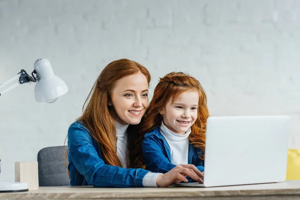 Mujer y niño mirando la pantalla del ordenador portátil - foto de stock