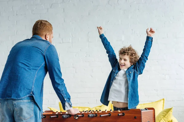 Hombre y niño lindo niño jugando fútbol de mesa - foto de stock