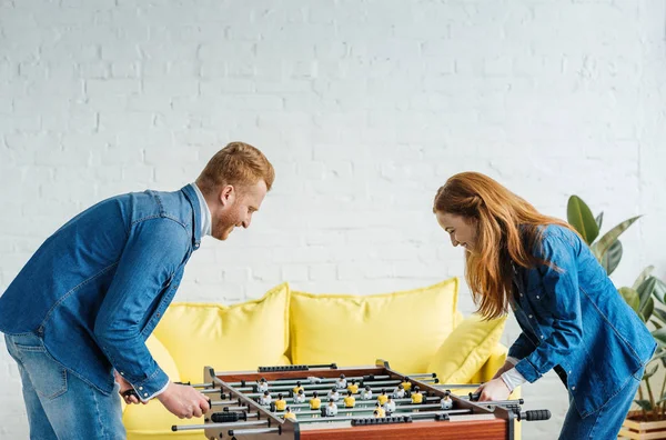 Joven feliz pareja jugando futbolín - foto de stock