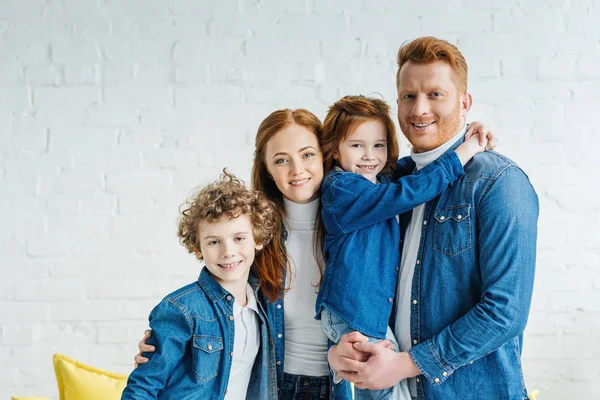 Happy redhead family hugging in light room — Stock Photo