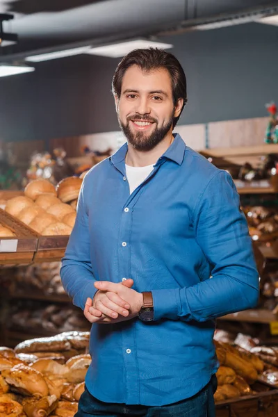 Retrato de homem sorridente olhando para a câmera no supermercado — Fotografia de Stock