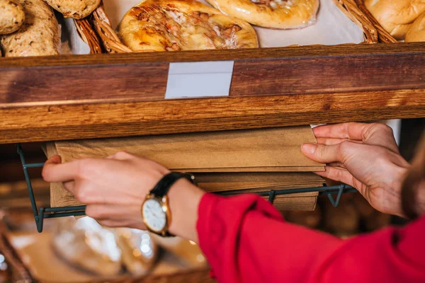 Partial view of woman taking paper bag for bread while shopping in supermarket — Stock Photo