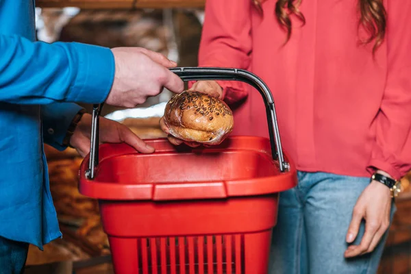 Cropped shot of couple with shopping basket shopping together in supermarket — Stock Photo