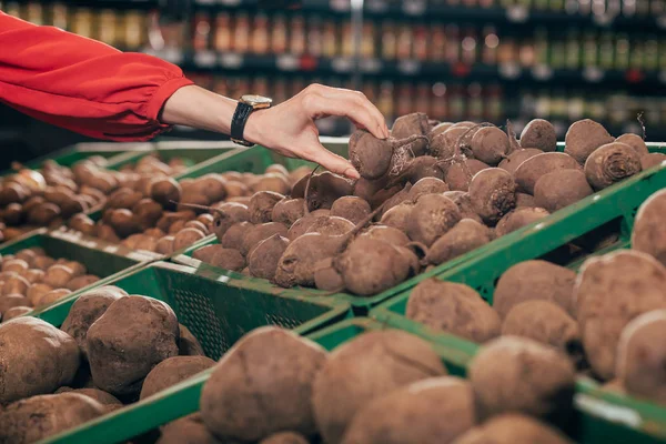 Vista parziale dell'acquirente che sceglie barbabietole fresche crude nell'ipermercato — Foto stock