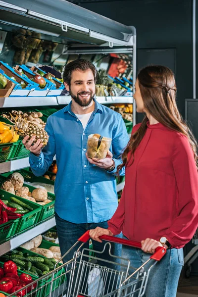 Paar mit Einkaufswagen beim gemeinsamen Einkauf im Supermarkt — Stockfoto