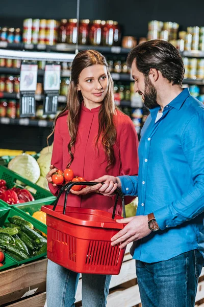 Casal com compras cesta compras juntos no supermercado — Fotografia de Stock