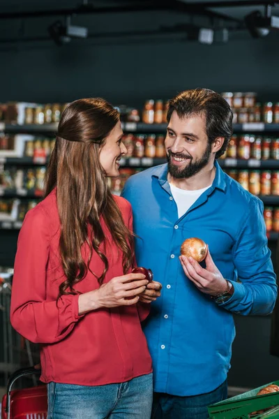 Ritratto di una coppia sorridente che fa shopping insieme al supermercato — Foto stock