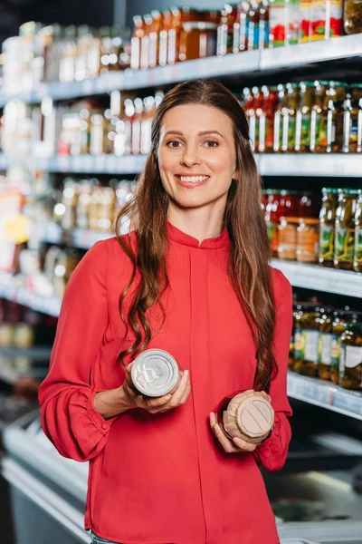 Portrait de femme souriante avec des produits dans les mains en hypermarché — Photo de stock