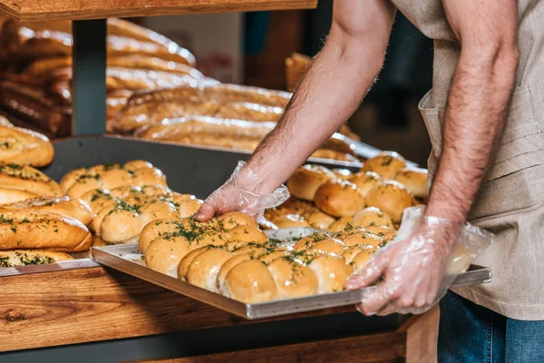 Tiro recortado de asistente de tienda masculina la organización de pastelería en el supermercado - foto de stock