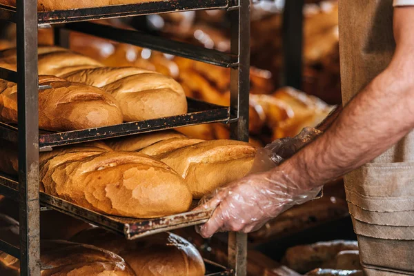 Cropped shot of shop assistant arranging loafs of bread in supermarket — Stock Photo