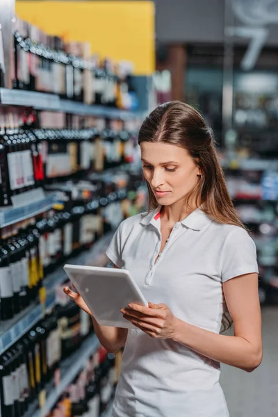 Portrait of shop assistant using digital tablet in hypermarket — Stock Photo