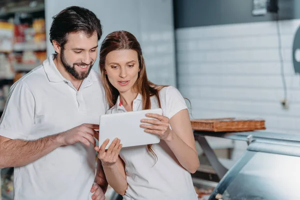 Portrait of shop assistants using digital tablet in hypermarket — Stock Photo