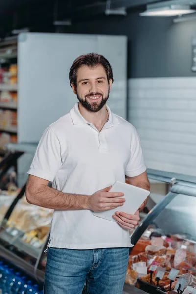 Ritratto di commessa sorridente con tablet nell'ipermercato — Foto stock