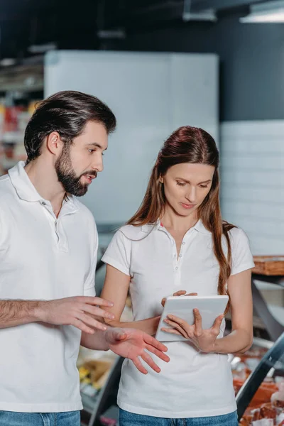 Retrato de assistentes de loja usando tablet digital no hipermercado — Fotografia de Stock