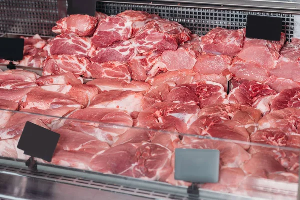 Vista de cerca de la carne cruda arreglada en la tienda de comestibles - foto de stock