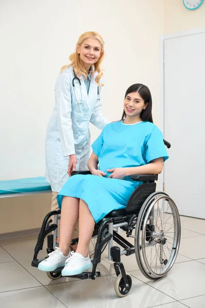 Obstetrician gynecologist and pregnant woman on wheelchair at maternity hospital — Stock Photo