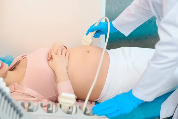 Обрізаний знімок акушер-гінеколога, що робить ультразвукове обстеження вагітної жінки — стокове фото