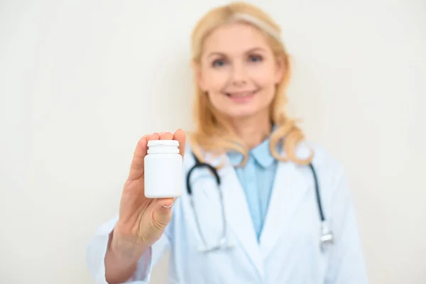 Close-up shot of female doctor with jar of pills on white — Stock Photo