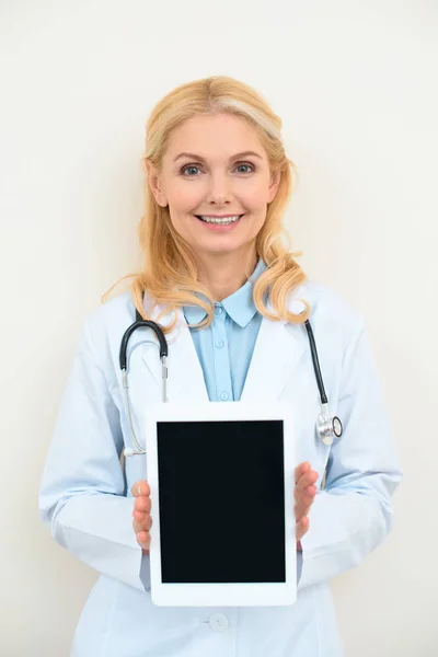 Feliz médico femenino con tableta digital en blanco - foto de stock