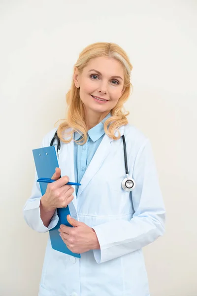Heureux médecin féminin avec presse-papiers sur blanc — Photo de stock