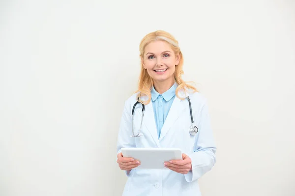 Щаслива жінка-лікар з цифровим планшетом на білому — стокове фото