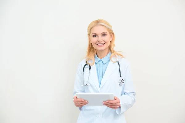 Felice medico femminile con tablet digitale su bianco — Foto stock