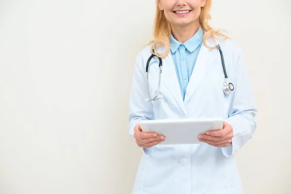 Colpo ritagliato di medico sorridente con tablet digitale su bianco — Foto stock