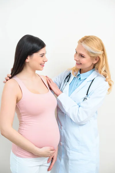 Щасливий зрілий акушер гінеколог, що підтримує вагітну жінку — стокове фото