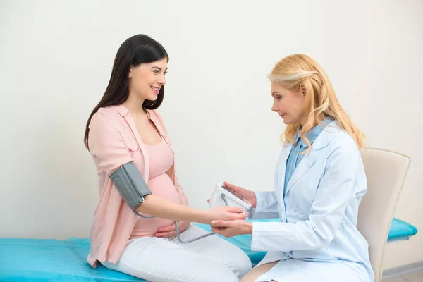 Ginecólogo obstetra medición de la presión arterial de la mujer embarazada - foto de stock