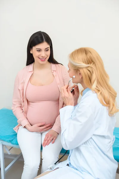 Ginecólogo obstetra con estetoscopio y mujer embarazada en la clínica - foto de stock