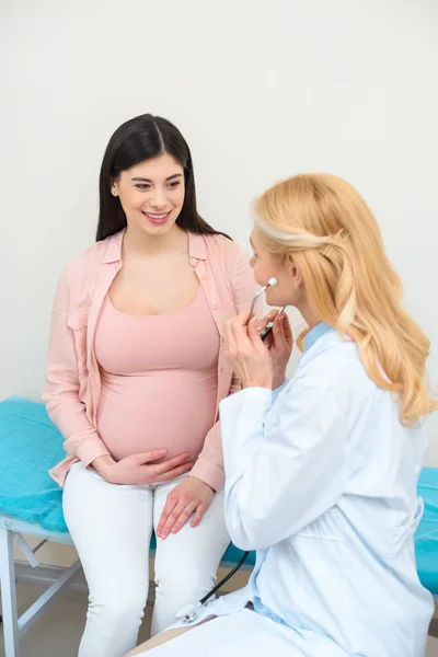 Ginecologo ostetrico con stetoscopio e donna incinta in clinica — Foto stock