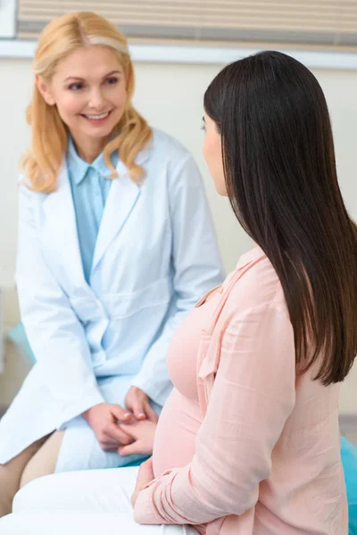 Mature obstetrician gynecologist holding hand of pregnant woman — Stock Photo