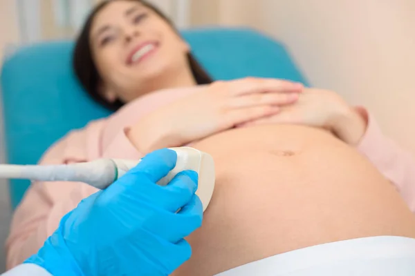 Primer plano de ginecólogo obstetra haciendo un examen de ultrasonido para la mujer embarazada - foto de stock