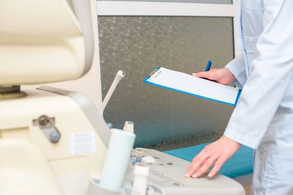 Obstetrician gynecologist in front of ultrasonic scanner with clipboard — Stock Photo